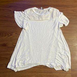 A girls shirt. White and has a design on the top